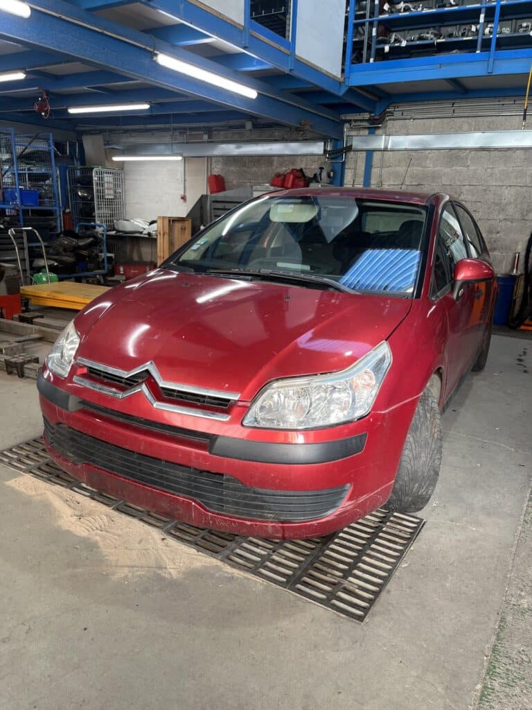 Citroën C4 I rouge vue de trois quarts avant dans l’atelier de la casse Jory & Fils à Esches (Oise)