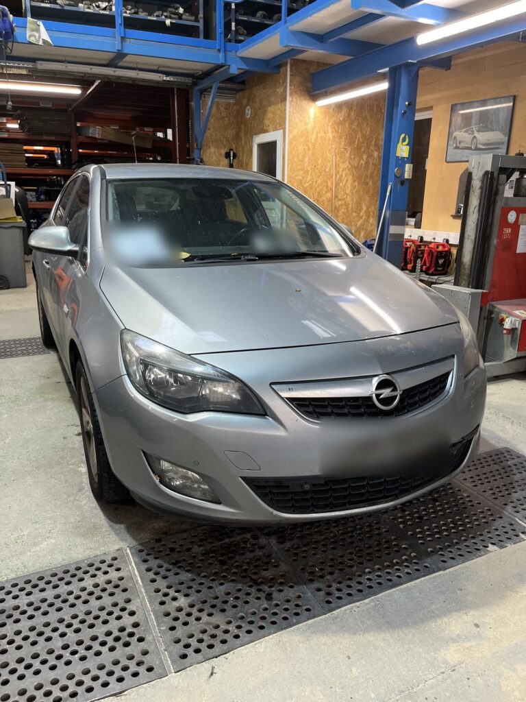 Opel Astra J gris clair vue de trois quarts avant dans l’atelier de la casse Jory & Fils à Esches (Oise)