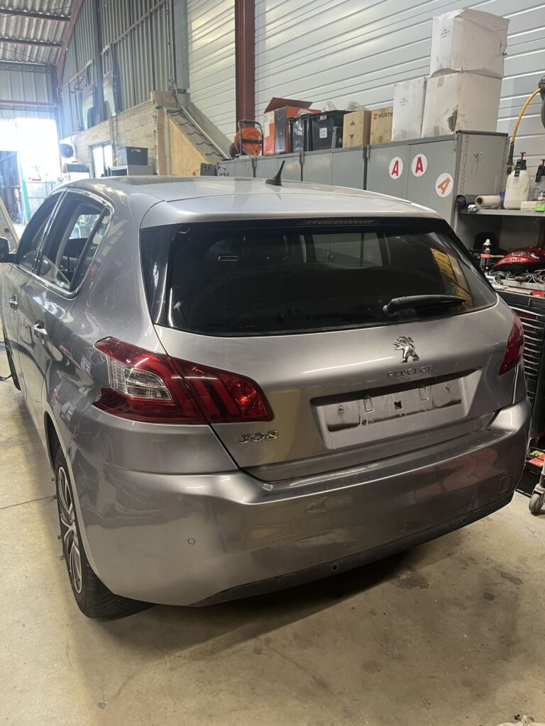 Peugeot 308 II grise vue de trois quarts arrière dans l’atelier de la casse Jory & Fils à Esches (Oise)